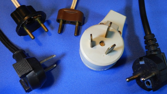 Figura 9 - Plugues incompatíveis com o novo padrão NBR de plugues e tomadas. Da esquerda para a direita: modelo de ferro de passar, de baquelite com e sem proteção, Nema 10 e Schuko.