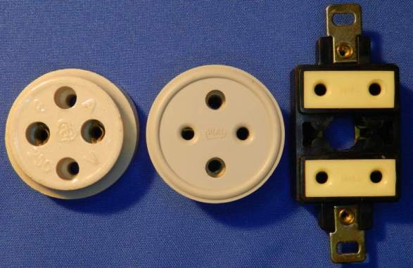 Figura 13 – Antigas tomadas de 2 pinos redondos, a da esquerda é de porcelana (louça) e as restantes são de baquelite.