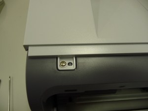 Figura 16 – Parafuso frontal da tampa superior, lado oposto às teclas de comando.