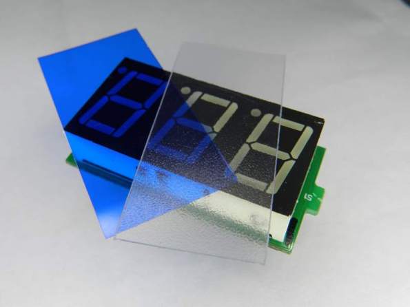 Figura 3 - Amperímetro desmontado, com película colorida, junto à lâmina difusora do amperímetro.