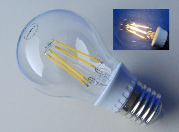 Figura 1 – Lâmpada de filamento LED tamanho A60 vendida no Brasil, marca Ourolux, de 6W, bivolt, emissão de 600 lumens, 10 mil horas de vida útil, selo Procel A. No detalhe, a mesma lâmpada, ligada.