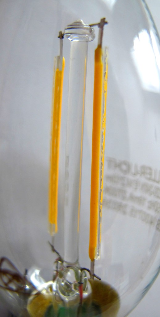 Figura 42 – Falhas na cobertura de fósforo em filamentos LED. Fonte: Wikimedia Commons [120].