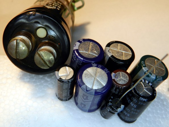 Figura 39 – Capacitores eletrolíticos úmidos de diversos tipos e tamanhos, onde é possível perceber as válvulas de proteção contra explosão.