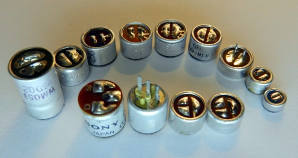 Figura 44 – Cápsulas de microfones de eletreto, de diversas épocas e fabricantes. O modelo mais pequeno, da direita, tem diâmetro de 6,5mm e ainda é maior do que a cápsula da câmera de ação.