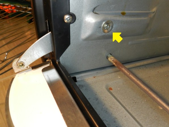 Figura 13 – A seta indica o parafuso de apoio para a haste deslizante, visto por dentro do forno.