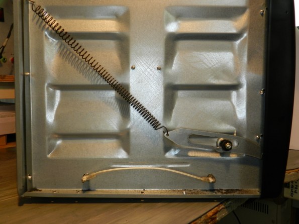 Figura 3 – Vista lateral do forno, após a remoção da tampa, com o mecanismo de recolhimento da porta. 