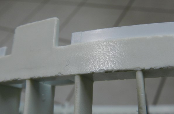 Figura 46 – Detalhe da grade traseira de um ventilador de mesa. Pode-se ver que a parte exposta à luz está craquelada e mais amarelada, diferente da parte coberta pela grade frontal (é a mesma peça plástica).
