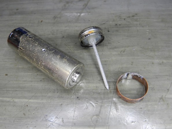 Fig. 12 – A carcaça, o polo negativo e o anel de cobre, que unidos formação a pilha falsa.