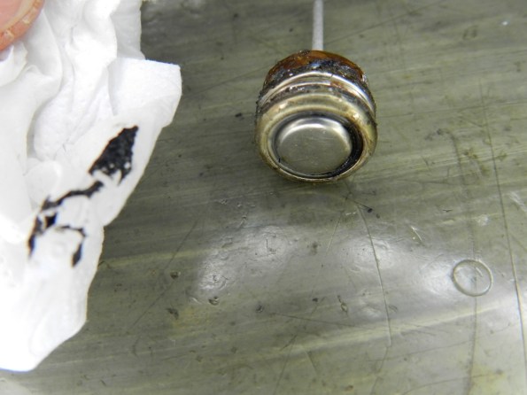 Fig. 13 – O aquecimento do polo negativo pela solda fez brotar um resíduo preto, através do anel de isolamento.