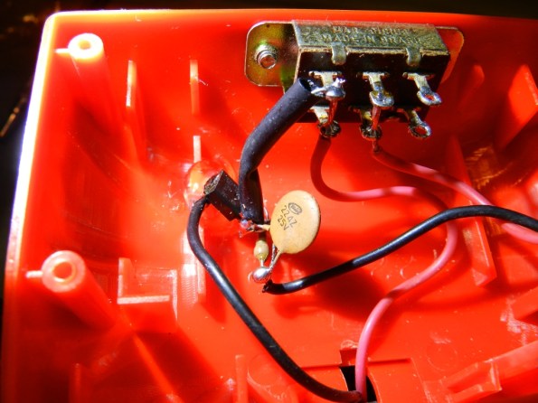 Fig. 21 – Fonte de corrente fixada com cola quente à lanterna. Observe que o BC548 está escondido atrás do capacitor cerâmico.